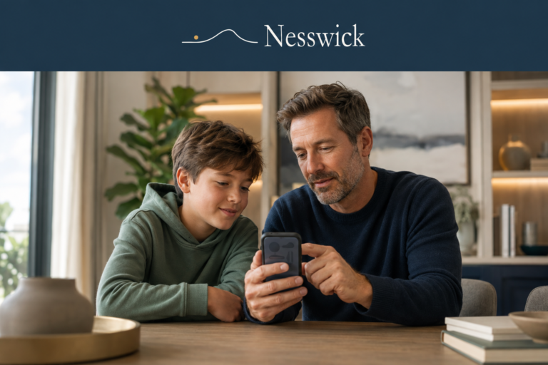 Father and son looking at a smartphone together at a dining table